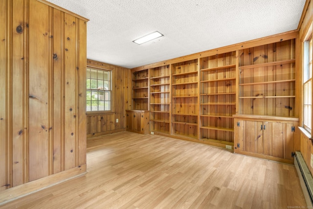 5 Brainerd Dr, Portland, CT 06480 - unfurnished room featuring baseboard heating, wooden walls, light wood finished floors, and a textured ceiling