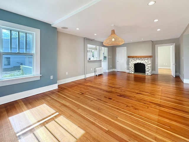 14 W Mystic Ave, Groton, CT 06355 - unfurnished living room featuring radiator heating unit, plenty of natural light, light wood-type flooring, baseboards, and recessed lighting