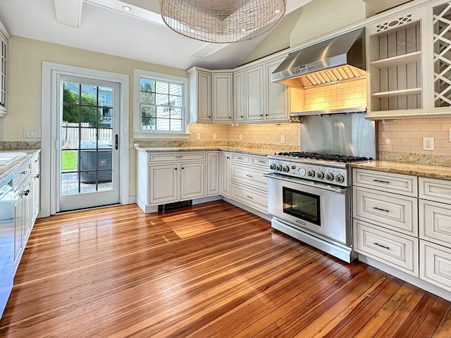 14 W Mystic Ave, Groton, CT 06355 - kitchen with high end stainless steel range oven, wall chimney exhaust hood, light wood-style floors, decorative backsplash, and vaulted ceiling
