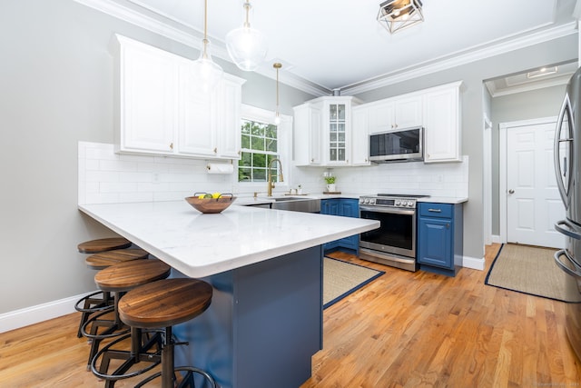 9 Tall Wood Dr, East Hampton, CT 06424 - kitchen with blue cabinetry, appliances with stainless steel finishes, a kitchen breakfast bar, white cabinetry, and crown molding