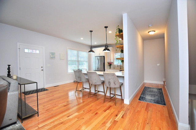 35 Ringgold St Unit 401, West Hartford, CT 06119 - kitchen featuring freestanding refrigerator, light wood-style floors, a breakfast bar area, white cabinets, and recessed lighting