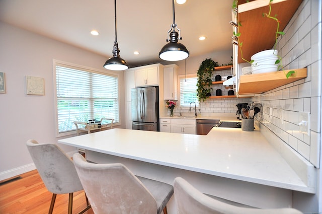 35 Ringgold St Unit 401, West Hartford, CT 06119 - kitchen with appliances with stainless steel finishes, a sink, backsplash, a peninsula, and light wood-style flooring