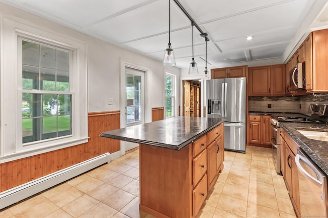 27 Maple St, Berlin, CT 06037 - kitchen with stainless steel appliances, a baseboard heating unit, a kitchen island, brown cabinets, and a wainscoted wall