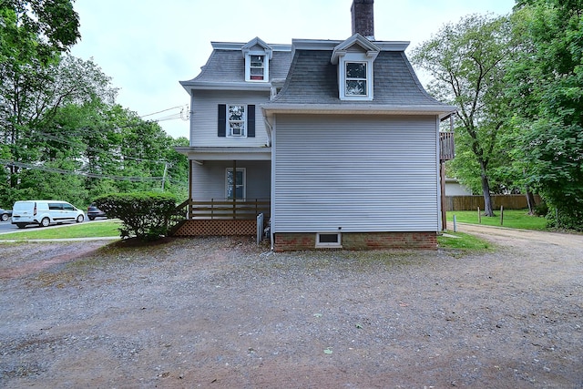 34 Woodbridge St, Manchester, CT 06042 - view of property exterior with a chimney, a porch, and mansard roof