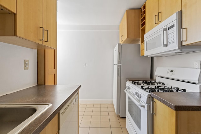 39 Glenbrook Rd Apt 2A, Stamford, CT 06902 - kitchen featuring white appliances, dark countertops, a sink, light tile patterned floors, and light brown cabinetry