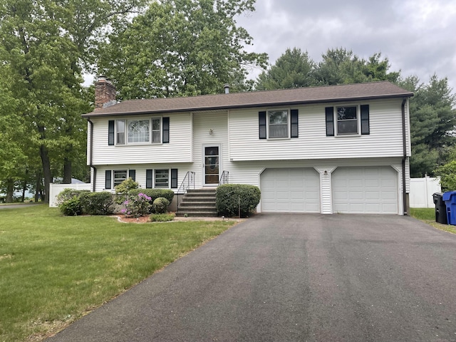 169 Brookfield St, South Windsor, CT 06074 - bi-level home with a garage, a chimney, driveway, and a front yard