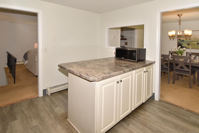 169 Brookfield St, South Windsor, CT 06074 - kitchen featuring stainless steel microwave, a baseboard heating unit, a chandelier, and wood finished floors