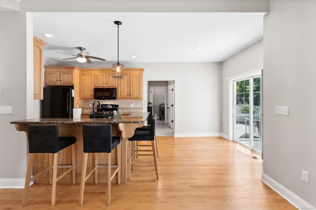 584 Meriden Ave Unit 1, Southington, CT 06489 - kitchen with black appliances, a kitchen bar, baseboards, light wood-type flooring, and recessed lighting