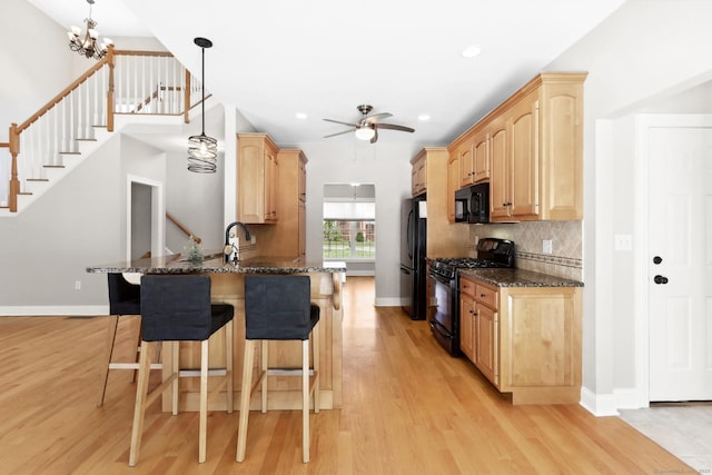 584 Meriden Ave Unit 1, Southington, CT 06489 - kitchen featuring black appliances, light brown cabinets, a kitchen breakfast bar, light wood-type flooring, and a peninsula