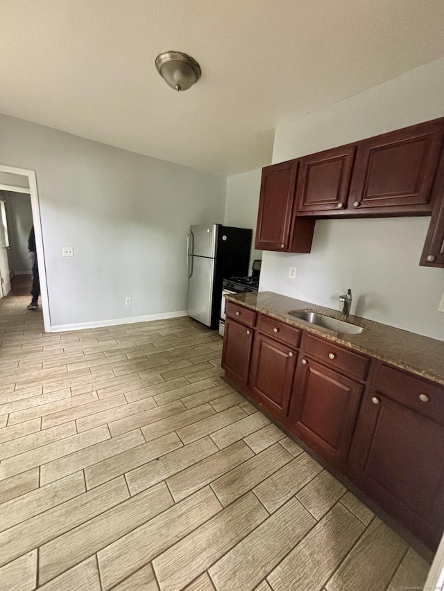 41 Lisbon St, Hartford, CT 06106 - kitchen with range with gas cooktop, light wood-style floors, a sink, and dark stone countertops