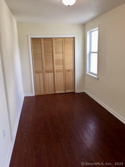41 Lisbon St, Hartford, CT 06106 - unfurnished bedroom with dark wood-type flooring, baseboards, and a closet