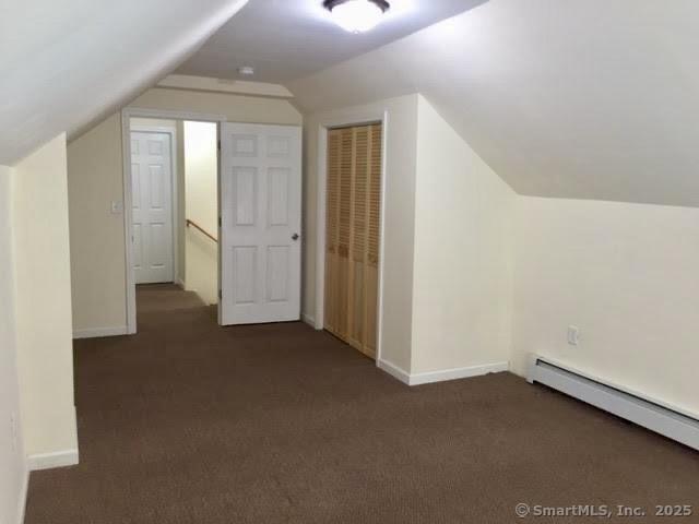 41 Lisbon St, Hartford, CT 06106 - additional living space with baseboard heating, lofted ceiling, dark carpet, and baseboards