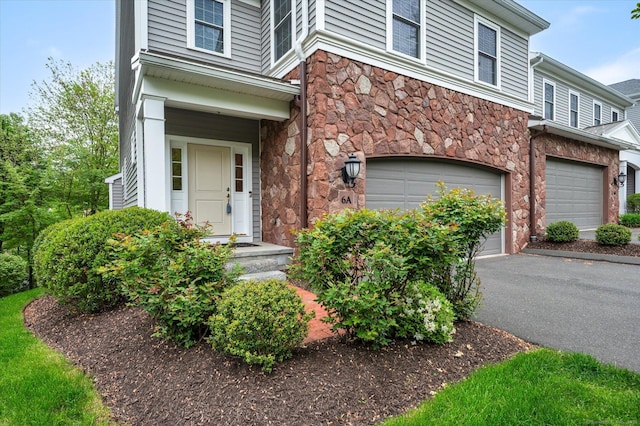 6 Mill Pond Ln Unit A, Simsbury, CT 06070 - view of front of home with an attached garage, stone siding, and asphalt driveway