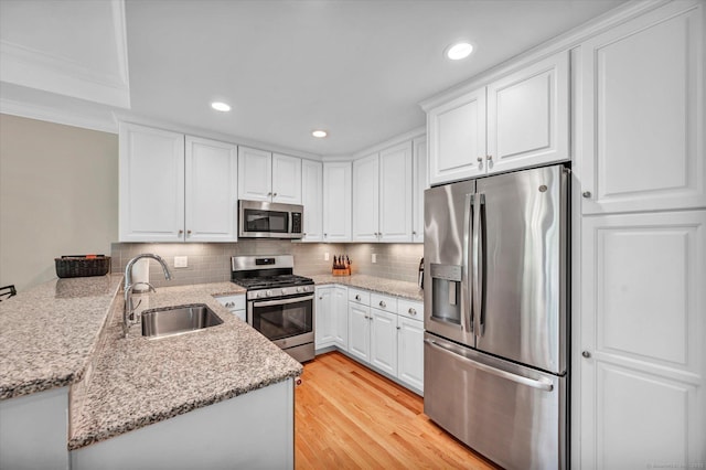 6 Mill Pond Ln Unit A, Simsbury, CT 06070 - kitchen featuring stainless steel appliances, a sink, a peninsula, white cabinets, and tasteful backsplash