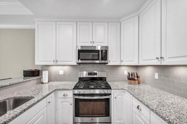 6 Mill Pond Ln Unit A, Simsbury, CT 06070 - kitchen featuring appliances with stainless steel finishes, white cabinetry, backsplash, and crown molding