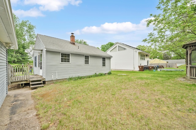 40 W View Dr, Enfield, CT 06082 - back of property featuring a chimney, a lawn, a deck, and roof with shingles