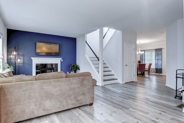 2 Linden Ct, Southington, CT 06489 - living area featuring stairway, a fireplace, light wood-type flooring, a chandelier, and baseboards