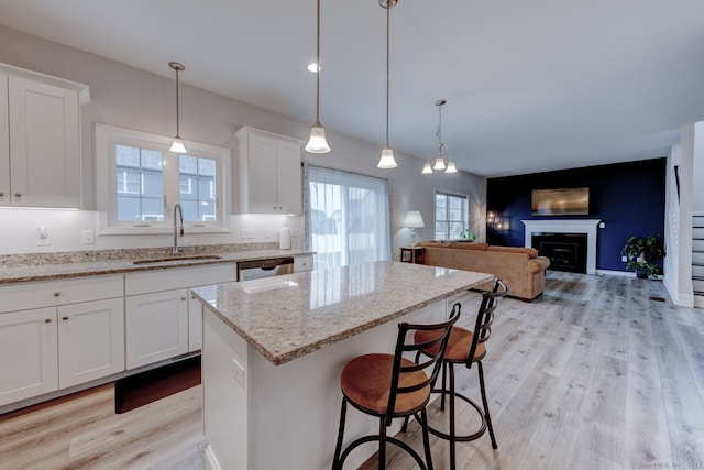 2 Linden Ct, Southington, CT 06489 - kitchen with a sink, dishwashing machine, light wood finished floors, a center island, and light stone countertops