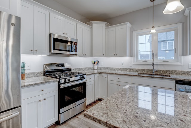 2 Linden Ct, Southington, CT 06489 - kitchen featuring appliances with stainless steel finishes, a sink, wood finished floors, white cabinets, and pendant lighting