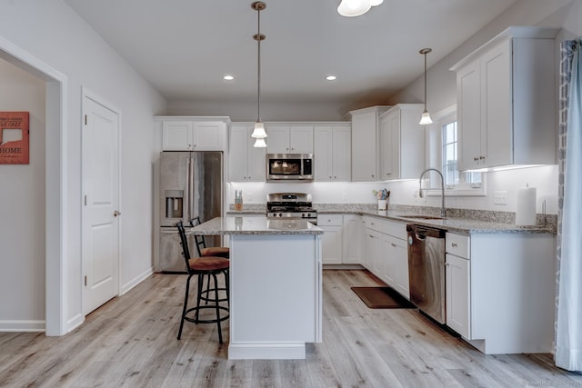 2 Linden Ct, Southington, CT 06489 - kitchen featuring stainless steel appliances, a sink, white cabinetry, a kitchen island, and light wood-style floors