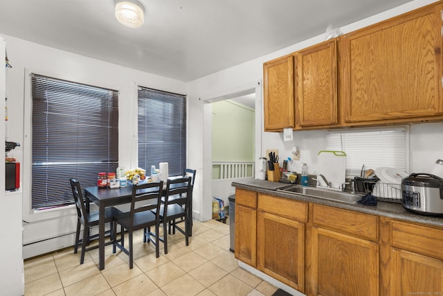 171 Frank St, New Haven, CT 06519 - kitchen featuring light tile patterned floors, dark countertops, brown cabinetry, and a sink