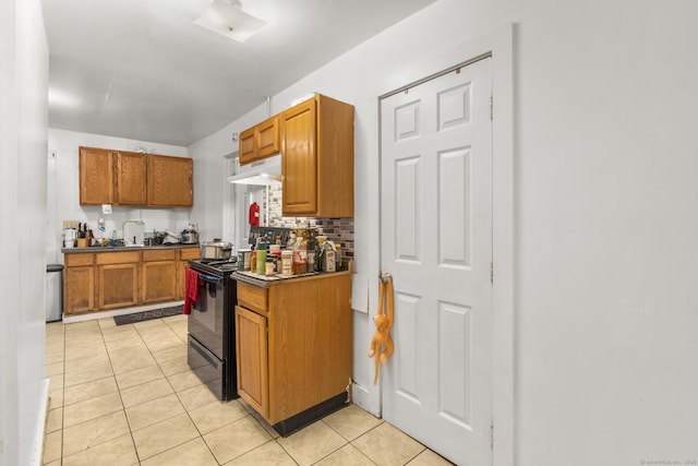 171 Frank St, New Haven, CT 06519 - kitchen with black range with electric stovetop, under cabinet range hood, light tile patterned flooring, backsplash, and brown cabinets
