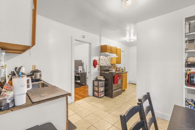 171 Frank St, New Haven, CT 06519 - kitchen with range with electric stovetop, light tile patterned floors, under cabinet range hood, and dark countertops