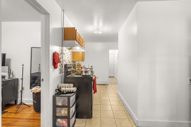 171 Frank St, New Haven, CT 06519 - kitchen with black electric range, under cabinet range hood, light tile patterned floors, and baseboards