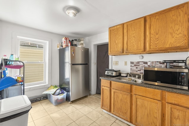 171 Frank St, New Haven, CT 06519 - kitchen featuring stainless steel appliances, a sink, brown cabinets, dark countertops, and light tile patterned floors