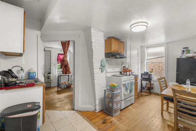 171 Frank St, New Haven, CT 06519 - kitchen with white range with gas stovetop, freestanding refrigerator, under cabinet range hood, a sink, and light wood-type flooring