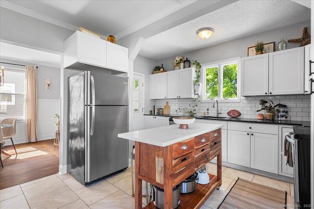 76 Geer Ave, Norwich, CT 06360 - kitchen featuring stainless steel appliances, a sink, decorative backsplash, crown molding, and white cabinetry