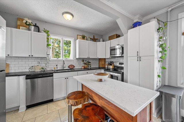 76 Geer Ave, Norwich, CT 06360 - kitchen with stainless steel appliances, a sink, tasteful backsplash, white cabinets, and light tile patterned floors