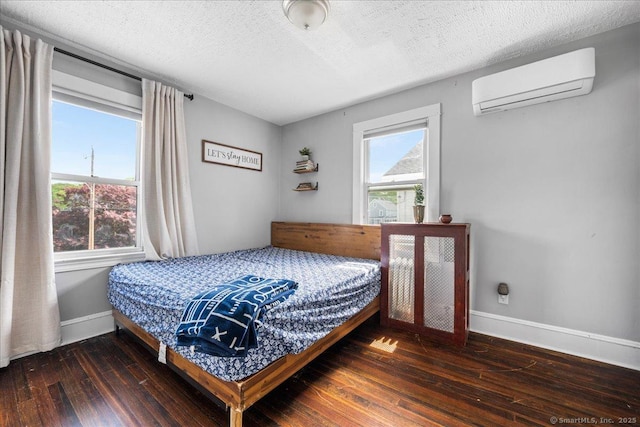 76 Geer Ave, Norwich, CT 06360 - bedroom with an AC wall unit, hardwood / wood-style floors, baseboards, and a textured ceiling