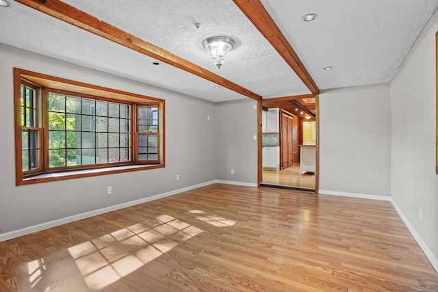 1975 Huntington Rd, Stratford, CT 06614 - unfurnished room with light wood-style flooring, beamed ceiling, and a textured ceiling