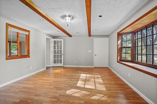 1975 Huntington Rd, Stratford, CT 06614 - empty room featuring wood finished floors, beamed ceiling, and a textured ceiling