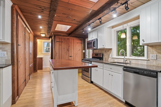 1975 Huntington Rd, Stratford, CT 06614 - kitchen with stainless steel appliances, wooden ceiling, dark countertops, and light wood-type flooring