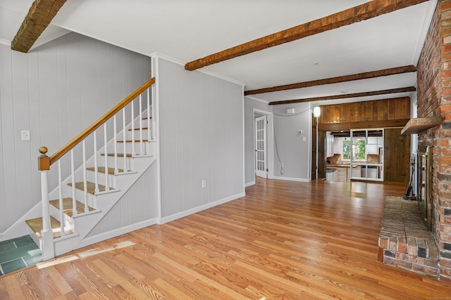 1975 Huntington Rd, Stratford, CT 06614 - unfurnished living room with wood finished floors, stairs, beam ceiling, and a fireplace