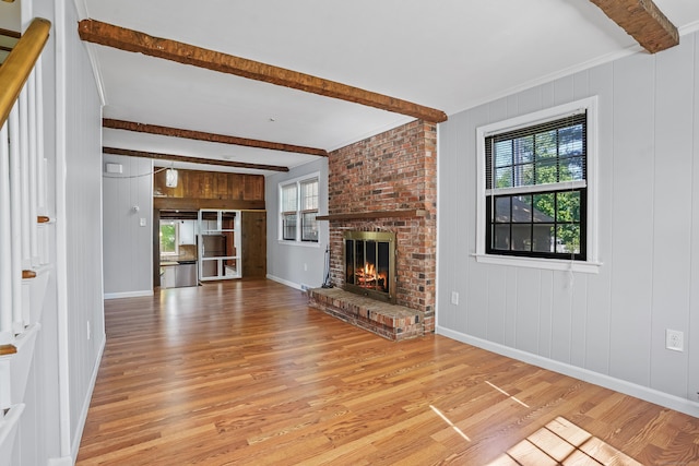 1975 Huntington Rd, Stratford, CT 06614 - unfurnished living room featuring beamed ceiling, light wood-style flooring, ornamental molding, and a fireplace
