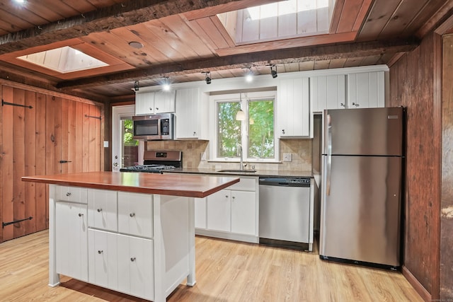 1975 Huntington Rd, Stratford, CT 06614 - kitchen featuring stainless steel appliances, a skylight, white cabinetry, butcher block countertops, and a wood ceiling with exposed beams