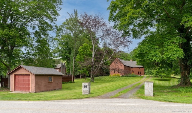96 Middle Haddam Rd, East Hampton, CT 06456 - view of front of property featuring a detached garage, a front lawn, an outdoor structure, a chimney, and view of wooded area