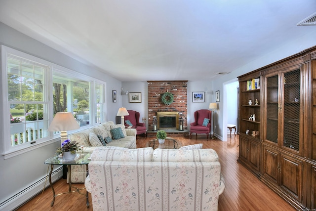 85 Oakridge Rd, Trumbull, CT 06611 - living area featuring a baseboard radiator, a fireplace, wood finished floors, and baseboards