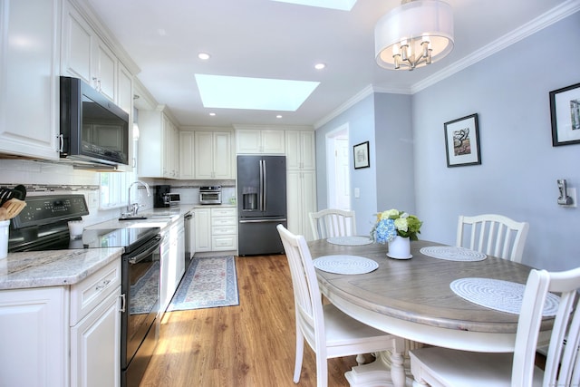85 Oakridge Rd, Trumbull, CT 06611 - kitchen featuring refrigerator with ice dispenser, range with electric stovetop, a skylight, a sink, and backsplash