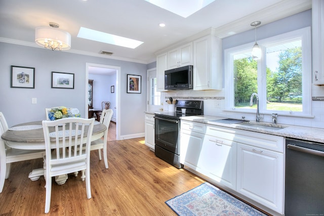 85 Oakridge Rd, Trumbull, CT 06611 - kitchen with electric range oven, dishwasher, a skylight, white cabinets, and tasteful backsplash