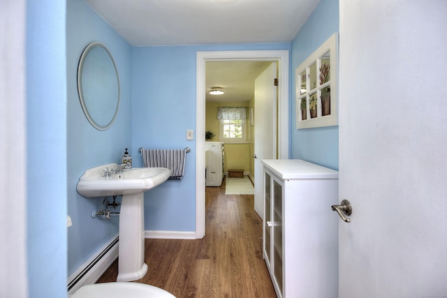 85 Oakridge Rd, Trumbull, CT 06611 - half bathroom with baseboard heating, wood finished floors, baseboards, and washer / clothes dryer