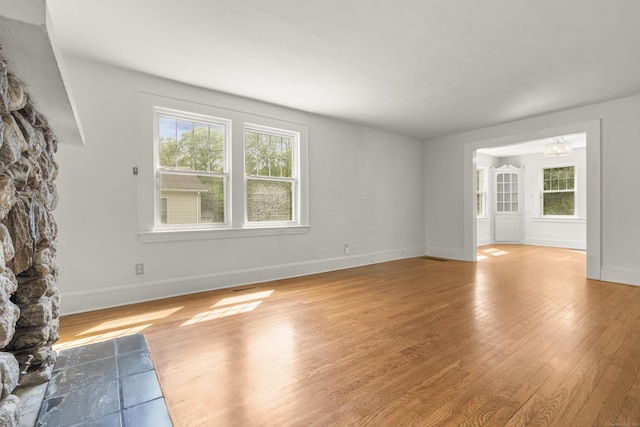 10 Paddock Pl, Milford, CT 06461 - unfurnished living room featuring wood finished floors, baseboards, and a chandelier