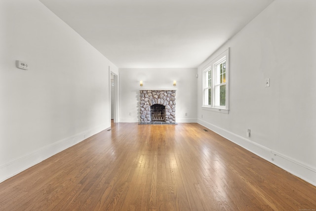 10 Paddock Pl, Milford, CT 06461 - unfurnished living room with a fireplace, wood-type flooring, and baseboards