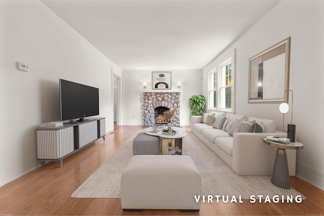10 Paddock Pl, Milford, CT 06461 - living room featuring light wood-type flooring, a stone fireplace, and baseboards