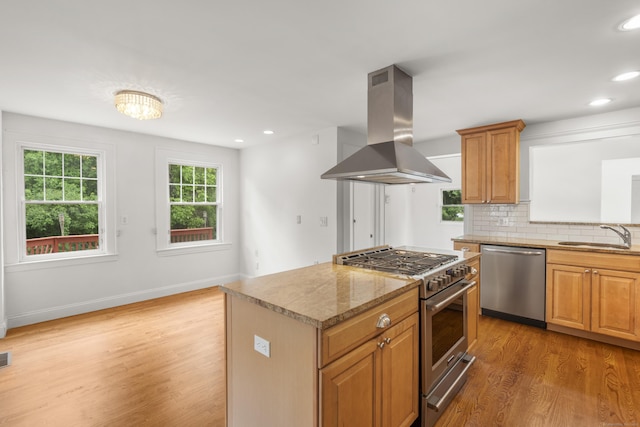 10 Paddock Pl, Milford, CT 06461 - kitchen with stainless steel appliances, island exhaust hood, a sink, light wood finished floors, and decorative backsplash