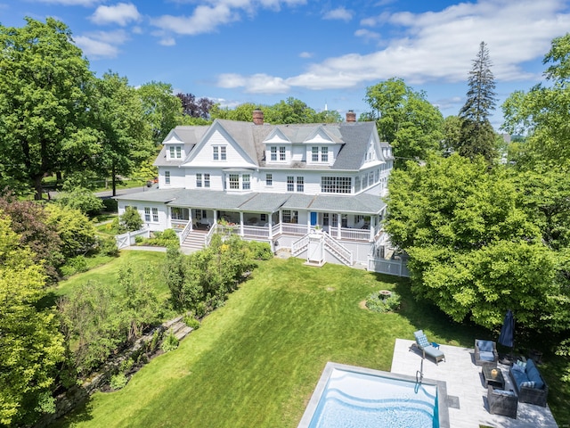 304 Main St, Ridgefield, CT 06877 - rear view of property with a chimney, a porch, a yard, an outdoor hangout area, and view of wooded area