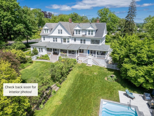 304 Main St, Ridgefield, CT 06877 - view of front facade with a chimney, covered porch, view of scattered trees, and an outdoor pool
